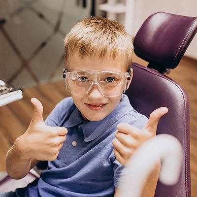 Boy giving thumbs up in dental chair